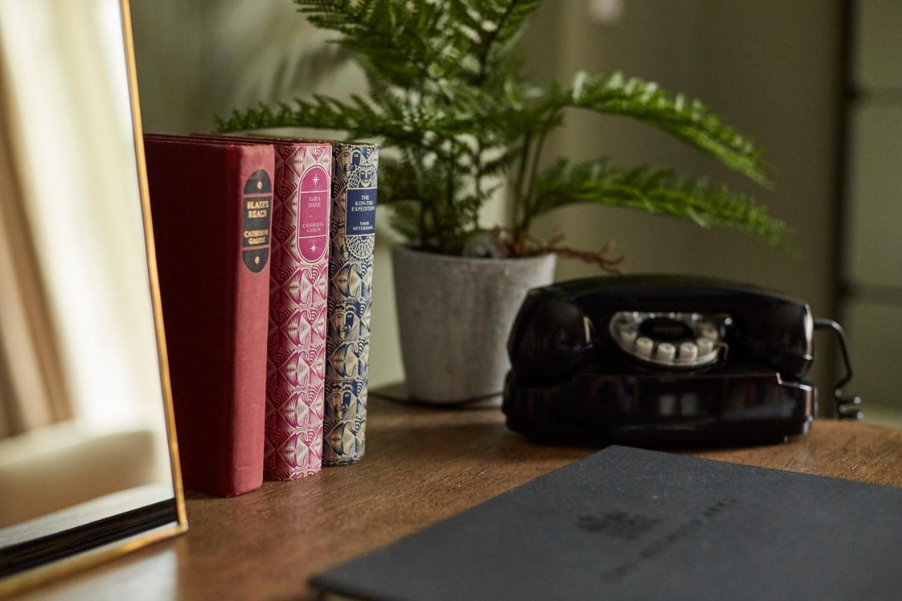 Hotel The Methuen Arms Corsham Esterno foto A 3D rendering of a desk with a telephone, books and a plant